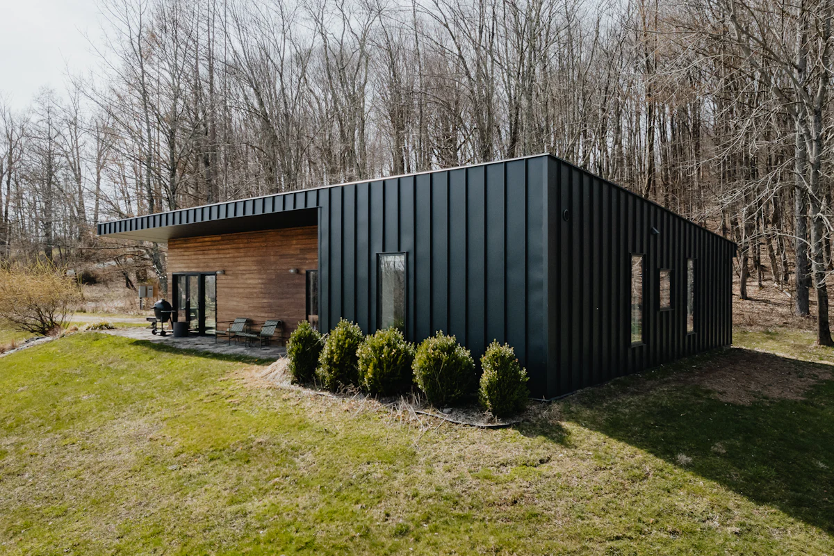 Modern black modular home in a grassy field