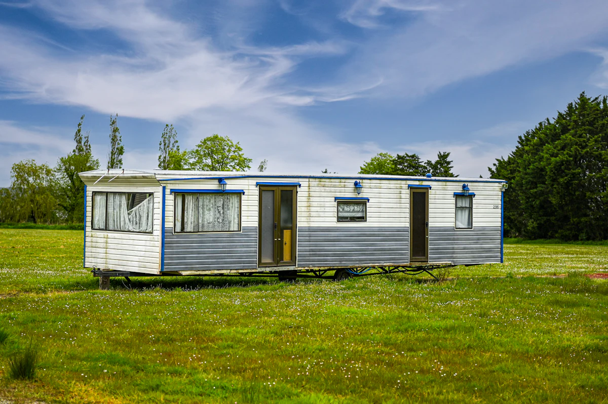 Single wide manufactured home sitting on a grassy lot